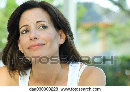 Stock Photo - Woman smiling, looking up, portrait. Fotosearch