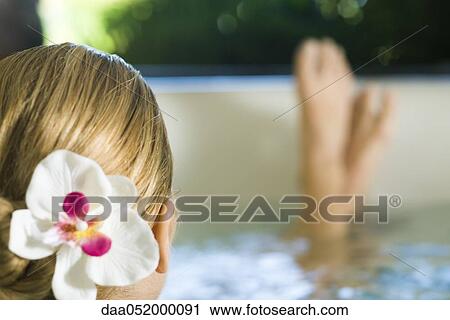 Stock Image - Woman soaking in spa, cropped view. Fotosearch