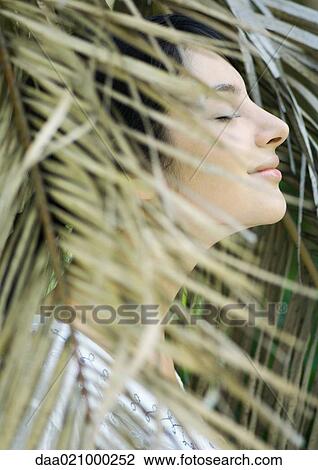 Woman standing in foliage, eyes closed, side view View Large Photo Image Stock Image - Woman standing in foliage, eyes closed, side view. Fotosearch