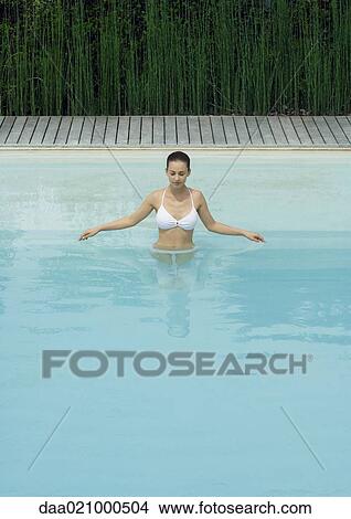 Woman standing in pool with arms out, looking down View Large Photo Image Picture - Woman standing in pool with arms out, looking down. Fotosearch