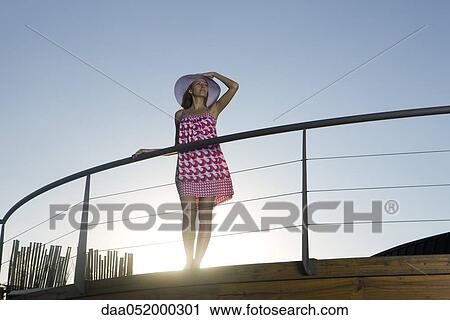 Woman standing on deck, looking at view View Large Photo Image Stock Image - Woman standing on deck, looking at view. Fotosearch
