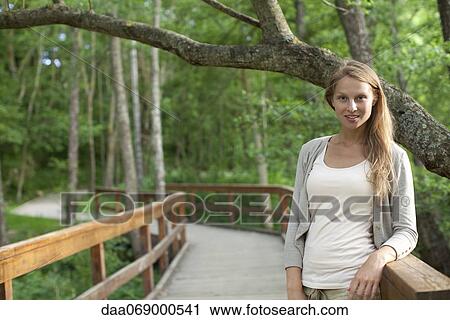 Woman standing on footpath through woods, portrait View Large Photo Image Stock Image - Woman standing on footpath through woods, portrait. Fotosearch