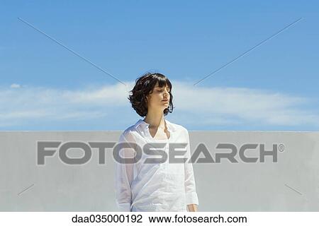 Woman standing outdoors with eyes closed View Large Photo Image Stock Image - Woman standing outdoors with eyes closed. Fotosearch