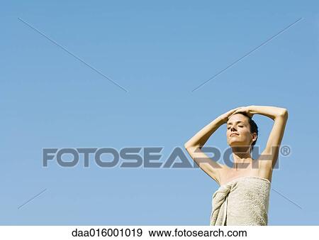 Stock Photo - Woman standing with hands on head. Fotosearch