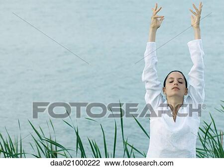 Woman stretching arms over head, lake in background View Large Photo Image Stock Image - Woman stretching arms over head, lake in background. Fotosearch