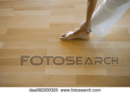 Stock Photography - Woman stretching, low section, cropped. Fotosearch