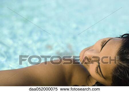 Woman sunbathing at swimming pool View Large Photo Image Stock Photography - Woman sunbathing at swimming pool. Fotosearch