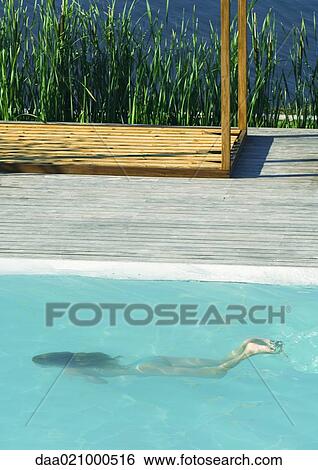 Woman swimming underwater in swimming pool, full length, high angle view View Large Photo Image Stock Photograph - Woman swimming underwater in swimming pool, full length, high angle view. Fotosearch