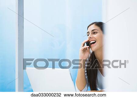 Woman talking on cell phone, looking away and smiling, cropped view View Large Photo Image Stock Image - Woman talking on cell phone, looking away and smiling, cropped view. Fotosearch
