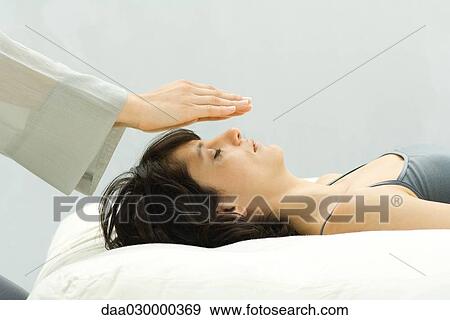 Woman undergoing alternative therapy treatment, therapist's hands over woman's head View Large Photo Image Stock Photo - Woman undergoing alternative therapy treatment, therapist's hands over woman's head. Fotosearch