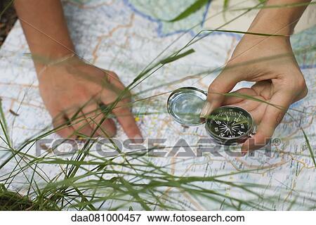 Woman using compass and map outdoors, cropped View Large Photo Image Stock Photo - Woman using compass and map outdoors, cropped. Fotosearch