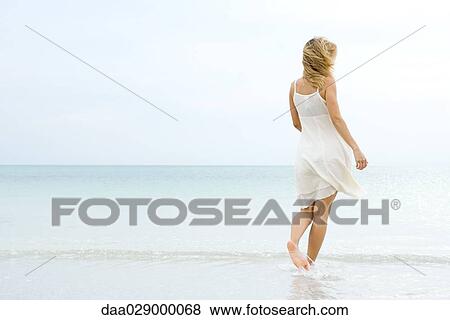 Woman walking at the beach, rear view View Large Photo Image Stock Photo - Woman walking at the beach, rear view. Fotosearch
