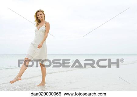 Woman walking at the beach, smiling at camera View Large Photo Image Stock Photograph - Woman walking at the beach, smiling at camera. Fotosearch