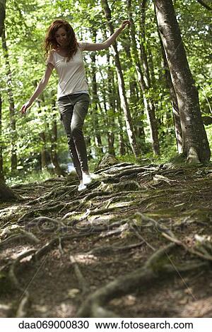 Woman walking on tree roots in woods View Large Photo Image Stock Image - Woman walking on tree roots in woods. Fotosearch