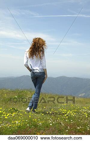 Woman walking through meadow View Large Photo Image Stock Image - Woman walking through meadow. Fotosearch