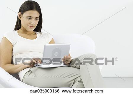 Woman watching portable DVD player, sitting in chair View Large Photo Image Stock Photograph - Woman watching portable DVD player, sitting in chair. Fotosearch
