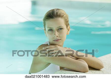 Stock Image - Woman wearing halter bathing suit, head and shoulders, leaning on edge of pool. Fotosearch