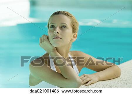 Stock Photography - Woman wearing halter bathing suit, head and shoulders, leaning on edge of pool. Fotosearch
