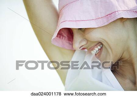 Woman wearing hat, smiling and looking down, close-up, cropped View Large Photo Image Stock Photo - Woman wearing hat, smiling and looking down, close-up, cropped. Fotosearch