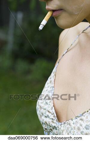 Woman wearing low cut top smoking, cropped View Large Photo Image Stock Photograph - Woman wearing low cut top smoking, cropped. Fotosearch