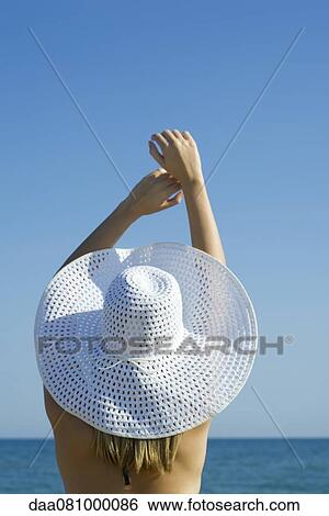 Woman wearing sun hat at the beach, rear view View Large Photo Image Stock Photograph - Woman wearing sun hat at the beach, rear view. Fotosearch