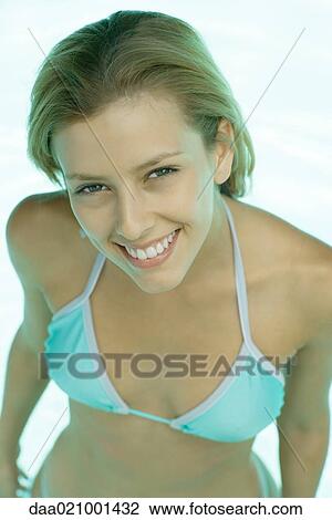 Stock Image - Woman wearing swimsuit, smiling, portrait, waist up. Fotosearch