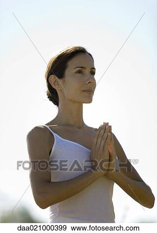 Stock Photo - Woman with arms in prayer position, waist up. Fotosearch