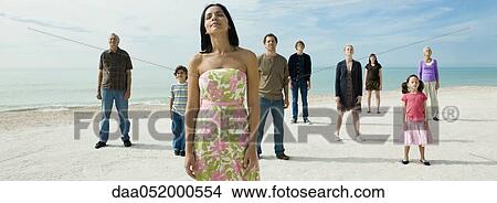 Picture - Woman with group of people on beach, eyes closed. Fotosearch