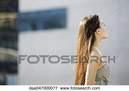 Woman with long hair standing outdoors, eyes closed, side view View Large Photo Image Stock Photo - Woman with long hair standing outdoors, eyes closed, side view. Fotosearch