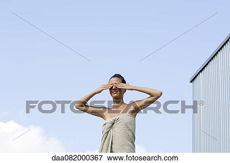 Woman wrapped in towel with hands covering eyes View Large Photo Image Stock Photo - Woman wrapped in towel with hands covering eyes. Fotosearch