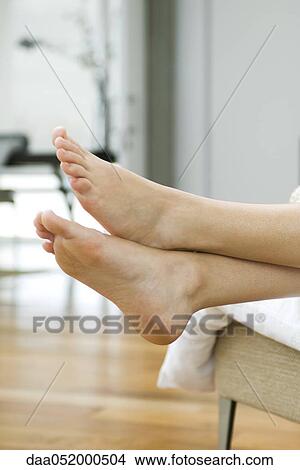 Picture - Woman's bare feet, legs crossed at ankle. Fotosearch