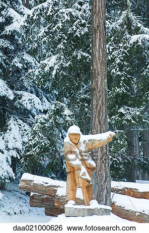 Wooden lumberjack by timber in snow View Large Photo Image Stock Photograph - Wooden lumberjack by timber in snow. Fotosearch