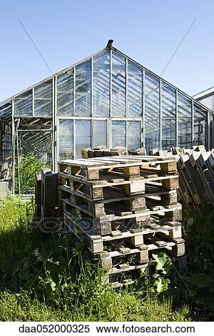 Wooden pallets stacked behind greenhouse View Large Photo Image Stock Photography - Wooden pallets stacked behind greenhouse. Fotosearch