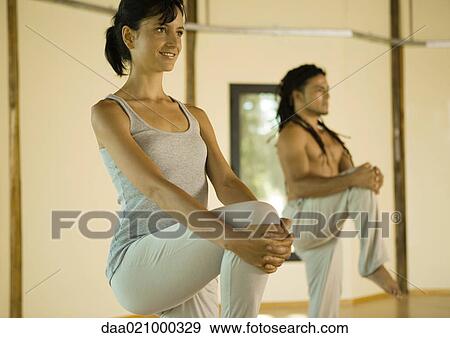 Yoga class standing, holding knees View Large Photo Image Stock Photo - Yoga class standing, holding knees. Fotosearch