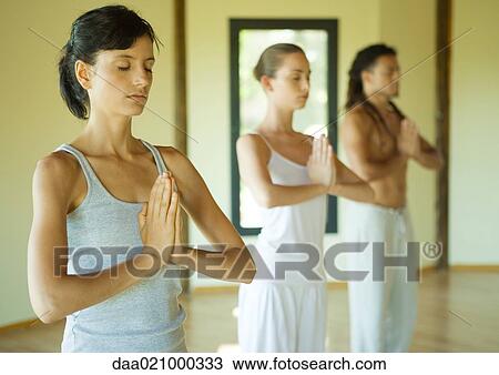 Yoga class standing in prayer position View Large Photo Image Stock Image - Yoga class standing in prayer position. Fotosearch