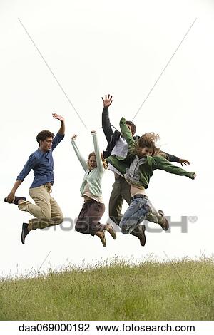 Young adults jumping on meadow View Large Photo Image Stock Image - Young adults jumping on meadow. Fotosearch