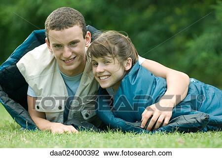 Young campers in sleeping bags, man's arm around woman's shoulder View Large Photo Image Stock Image - Young campers in sleeping bags, man's arm around woman's shoulder. Fotosearch