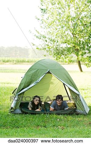 Young campers lying down in tent, smiling at camera View Large Photo Image Stock Photo - Young campers lying down in tent, smiling at camera. Fotosearch
