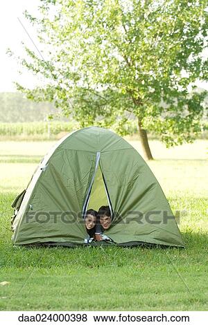 Young campers peeking heads out of tent View Large Photo Image Stock Photo - Young campers peeking heads out of tent. Fotosearch