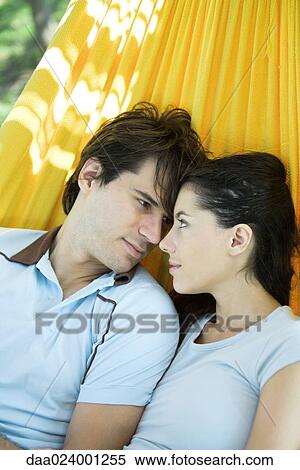 Young couple lying in hammock, looking at each other View Large Photo Image Stock Photography - Young couple lying in hammock, looking at each other. Fotosearch
