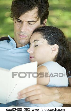 Young couple outdoors, man reading while woman sleeps with head on his shoulder View Large Photo Image Stock Image - Young couple outdoors, man reading while woman sleeps with head on his shoulder. Fotosearch