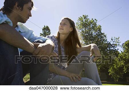 Young couple talking together outdoors View Large Photo Image Stock Photo - Young couple talking together outdoors. Fotosearch