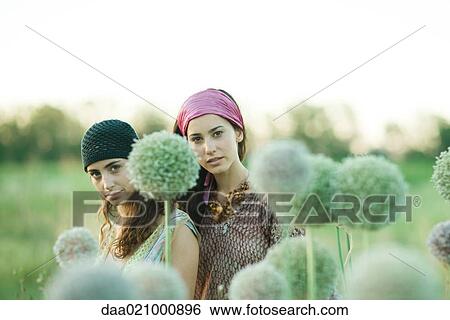 Young hippie women outdoors, allium flowers in blurred foreground View Large Photo Image Stock Photograph - Young hippie women outdoors, allium flowers in blurred foreground. Fotosearch