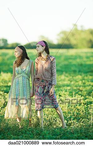Young hippie women standing in field, looking away, full length View Large Photo Image Stock Photo - Young hippie women standing in field, looking away, full length. Fotosearch