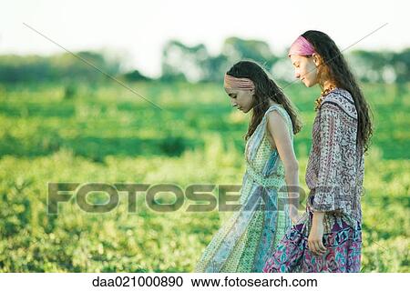Young hippie women walking through field, side view View Large Photo Image Stock Image - Young hippie women walking through field, side view. Fotosearch