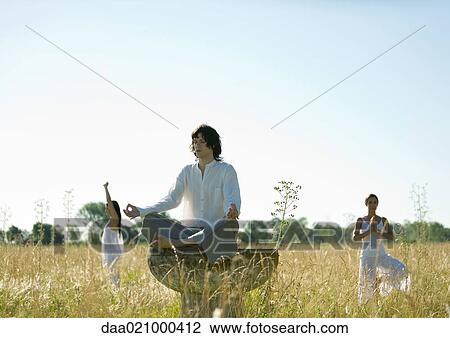 Young male and females doing yoga in field View Large Photo Image Stock Image - Young male and females doing yoga in field. Fotosearch