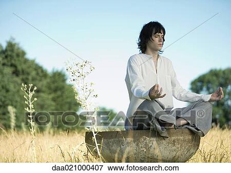 Young male meditator in lotus position in field View Large Photo Image Stock Photo - Young male meditator in lotus position in field. Fotosearch