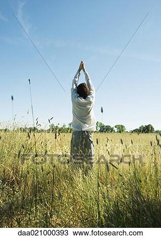 Young male standing in field, arms up, rear view View Large Photo Image Stock Image - Young male standing in field, arms up, rear view. Fotosearch