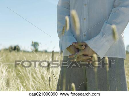 Young male standing in field, hands clasped, cropped view of mid section View Large Photo Image Stock Image - Young male standing in field, hands clasped, cropped view of mid section. Fotosearch