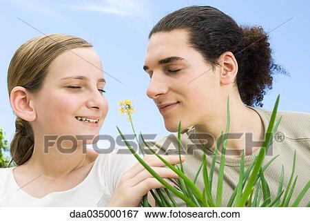Young man and preteen girl smelling flowering aloe plant, eyes closed View Large Photo Image Stock Photo - Young man and preteen girl smelling flowering aloe plant, eyes closed. Fotosearch